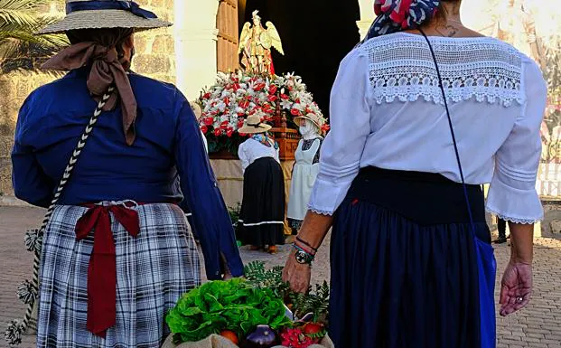 Dos mujeres llevan alimentos ante el santo, en Tuineje. /Javier MELIÁN / aCFI PRESs
