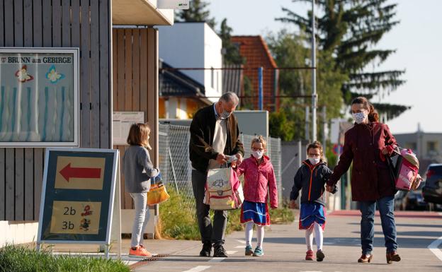 Unos padres acompañan a sus hijos al colegio en la localidad austriaca de Brunn am Gebirge. /lEONHARD fOEGER / Reuters