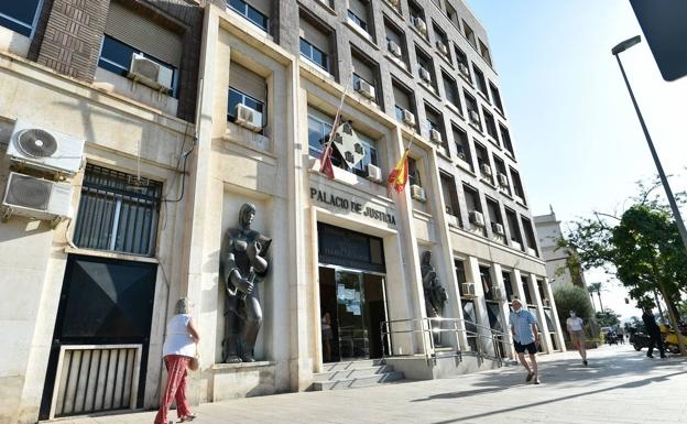 Ciudadanos pasean frente a la sede del Palacio de Justicia de Murcia, una de las sedes judiciales.