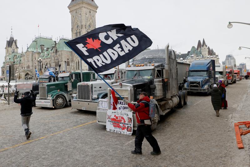 Camioneros protestan ante el Parlamento con banderas contra el primer ministro de Canadá, Justin Tradeau, por imponer la vacunación obligatoria para cruzar la frontera a EE UU.