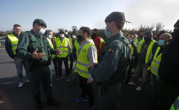 Two agents of the Civil Guard speak with the members of a picket 