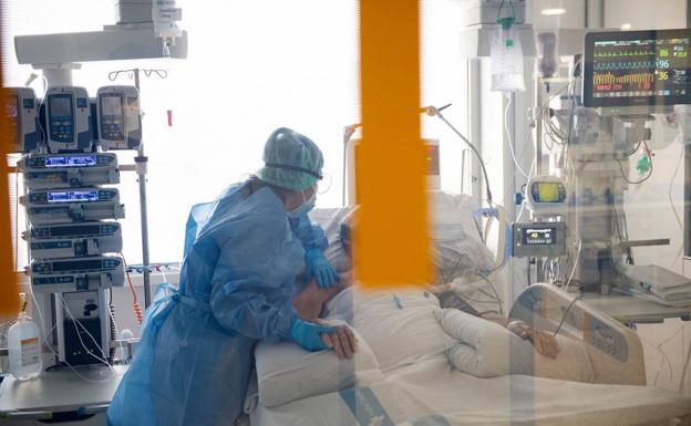 Una sanitaria atiende a un pacientes de covid en el hospital Bellvitge de Barcelona./AFP