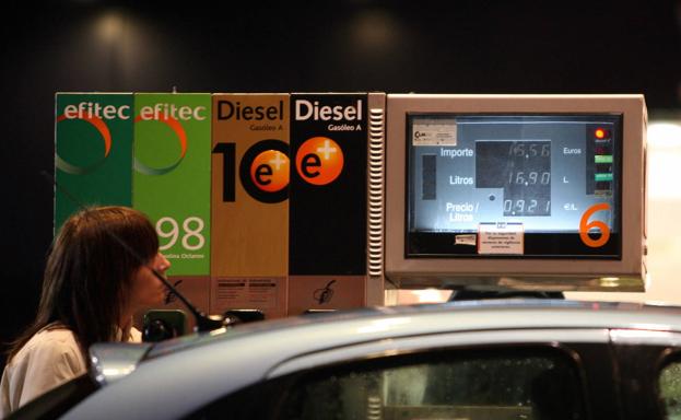 Una mujer llena el depósito de su automóvil en una gasolinera de Madrid. /efe