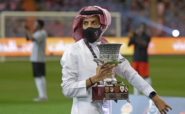 Un miembro de la organización de la Supercopa de España 2022 en Arabia Saudí, con el trofeo. /AFP
