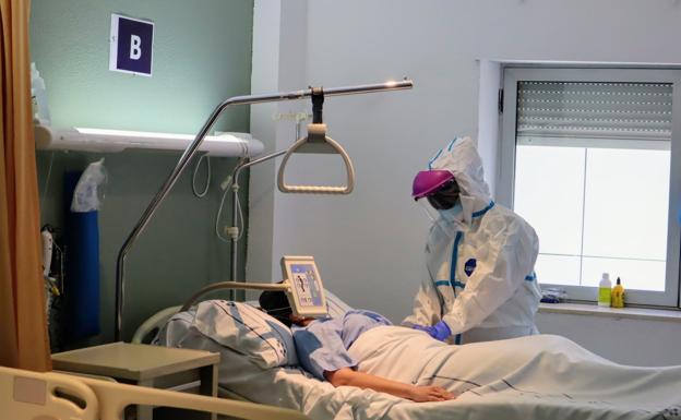 Imagen de archivo de una sanitaria atendiendo a una paciente de covid en el hospital de La Canderia, en Tenerife. / C7