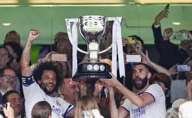 Marcelo y Benzema sostienen el trofeo al campeón de Liga 2021-22.