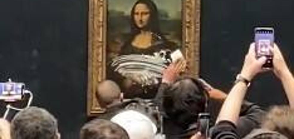A man dressed as a woman attacks 'La Gioconda' with a cake
