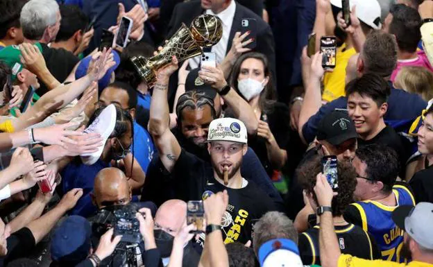 Stephen Curry (30) sostiene el trofeo de MVP después de derrotar a los Boston Celtics en el sexto partido de la final de la NBA de 2022 en el TD Garden.
