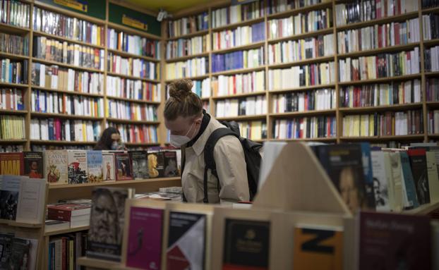 Un lector, hojeando un libro en una libreria./Isabel B. Permuy