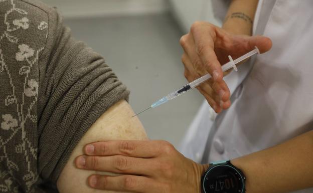 A health worker administers a flu shot.
