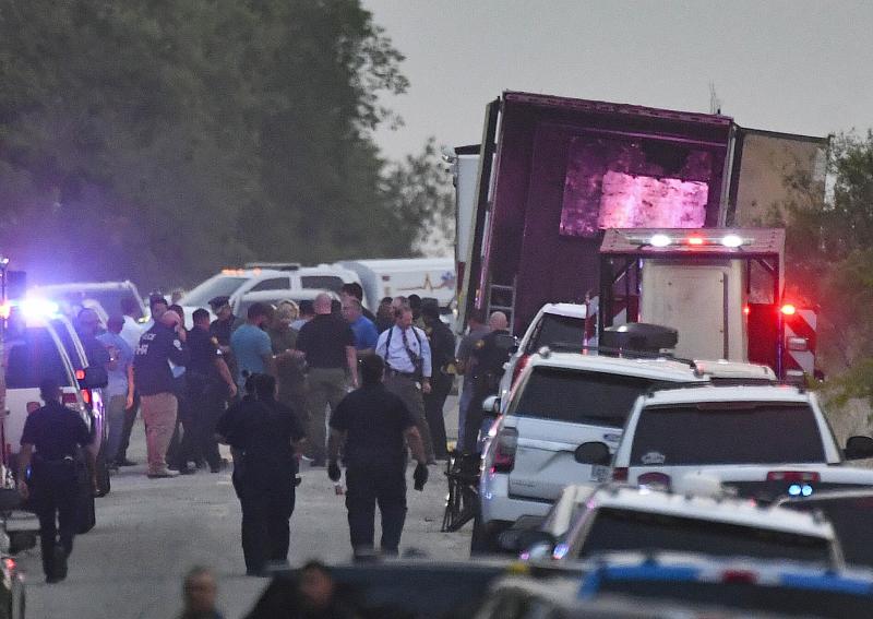 Policías y forenses trabajan en el camión lleno de migrantes que fue abandonado en una carretera de Texas./Billy Calzada/efe