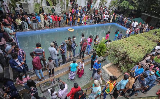 Cientos de personas reunidos alrededor de la piscina del palacio presidencial tras el asalto./efe