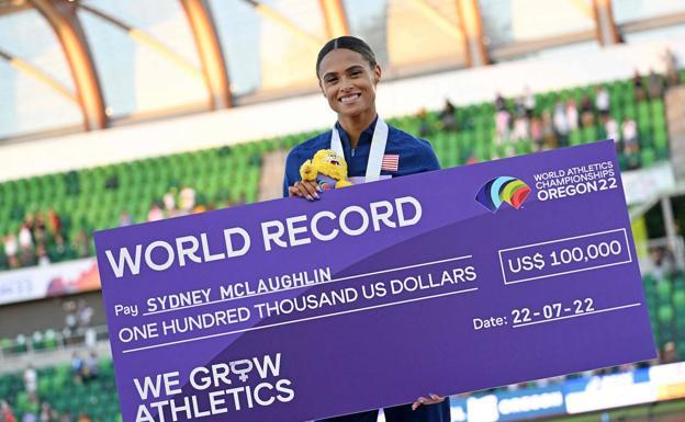 Sydney McLaughlin poses with the check received for her best world record in the 400 hurdles. 