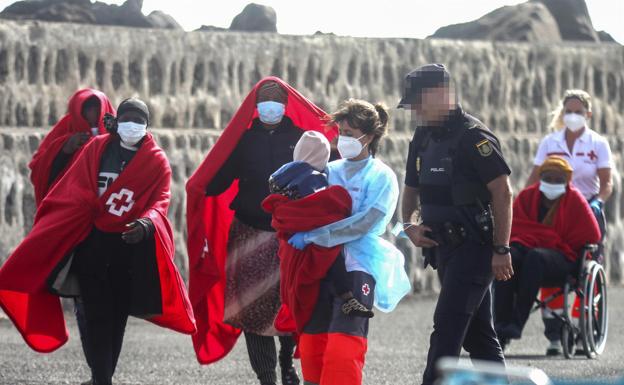 The Red Cross wraps a minor in a blanket after the arrival of a pneumatic boat in Lanzarote.