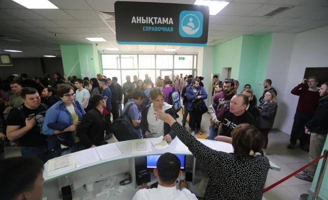 Ciudadanos rusos huidos a Kazajistán para escapar de la movilización parcial decretada por Putin hacen cola en un centro de Almaty para recibir un documento de residencia temporal./Pavel Mikheyev / reuters