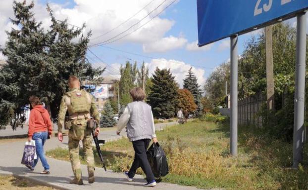 Un soldado ruso acompaña a dos civiles a un punto de votación durante los referéndums para la anexión de los territorios ocupados a Rusia./ALCALDÍA DE MELITÓPOL