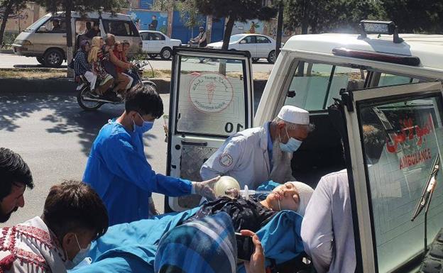 Efectivos medicos evacúan a una joven herida tras el ataque suicida contra una escuela, este viernes en Kabul.