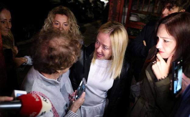 Giorgia Meloni, charla con una de sus votantes, en la noche electoral italiana del pasado domingo /reuters
