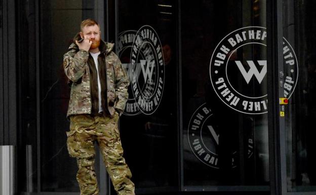 Un hombre vestido con camuflaje militar se encuentra en la entrada de la nueva sede del grupo Wagner durante la inauguración oficial del bloque de oficinas en San Petersburgo. 