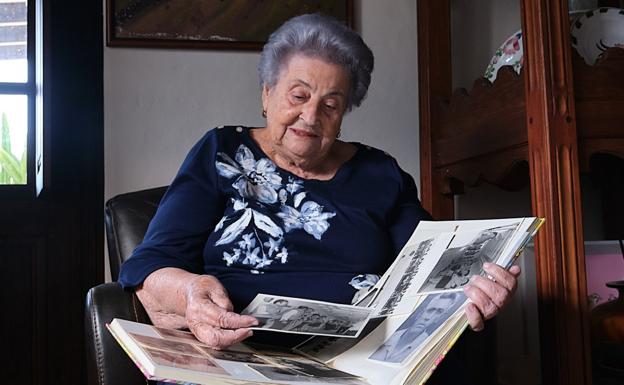 Carmen, de 85 años, con el álbum de fotos de su estancia en Caracas. 