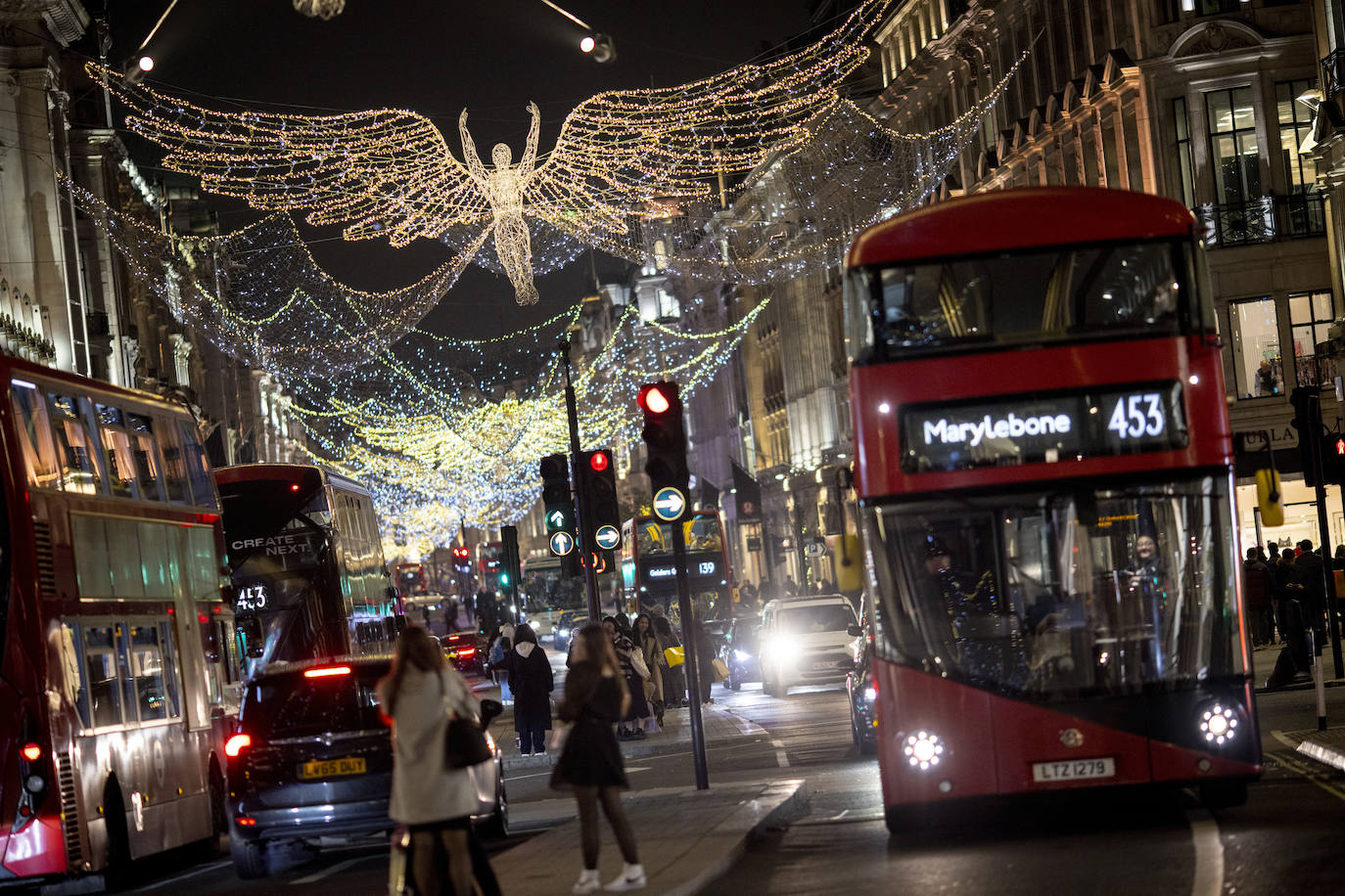 Compradores y peatones pasan bajo las luces navideñas en Oxford Street en Londres, Gran Bretaña.