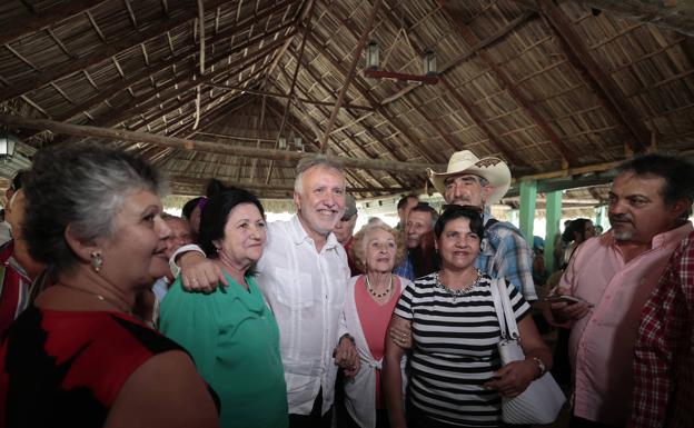 Neighbors from the town of Cabaiguán approach Ángel Víctor Torres on his visit to the country. 